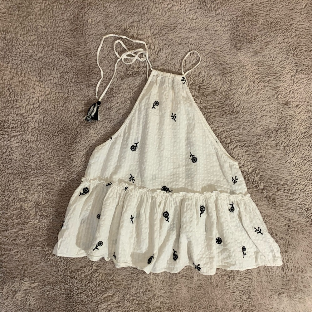 White tank top with embroidered design on it